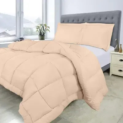 Beige comforter set on a bed in a bedroom with a gray headboard and white nightstand.