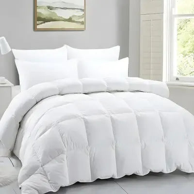 White comforter set on a bed with pillows and a window in the background