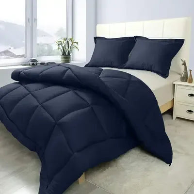Navy blue comforter set on a bed in a bedroom with a white headboard and nightstands.