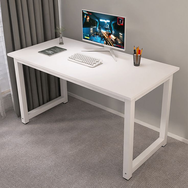 White desk with computer setup in a room with gray walls and carpet.