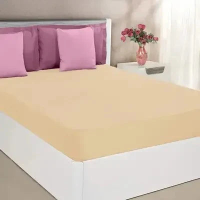 Bed with pink bedding and a vase of flowers on a nightstand.