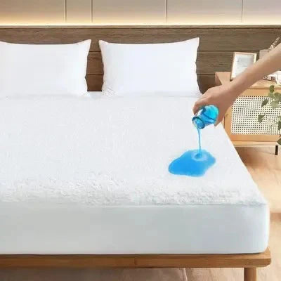 Person applying a blue gel to a mattress pad on a bed.
