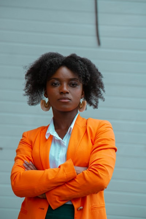 Woman wearing an orange blazer with a neutral background